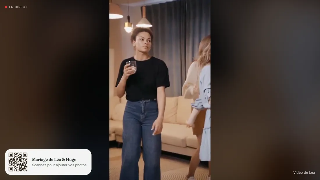 Le diaporama en direct sur un grand écran : une photo en plein cadre sur fond flouté, le badge « En direct », et un QR code en bas à gauche invitant à scanner pour ajouter ses photos et vidéos.